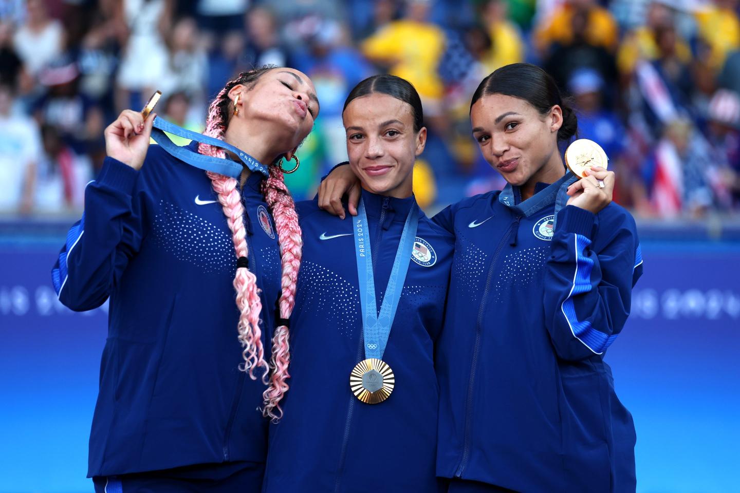 athletes pose with gold medals