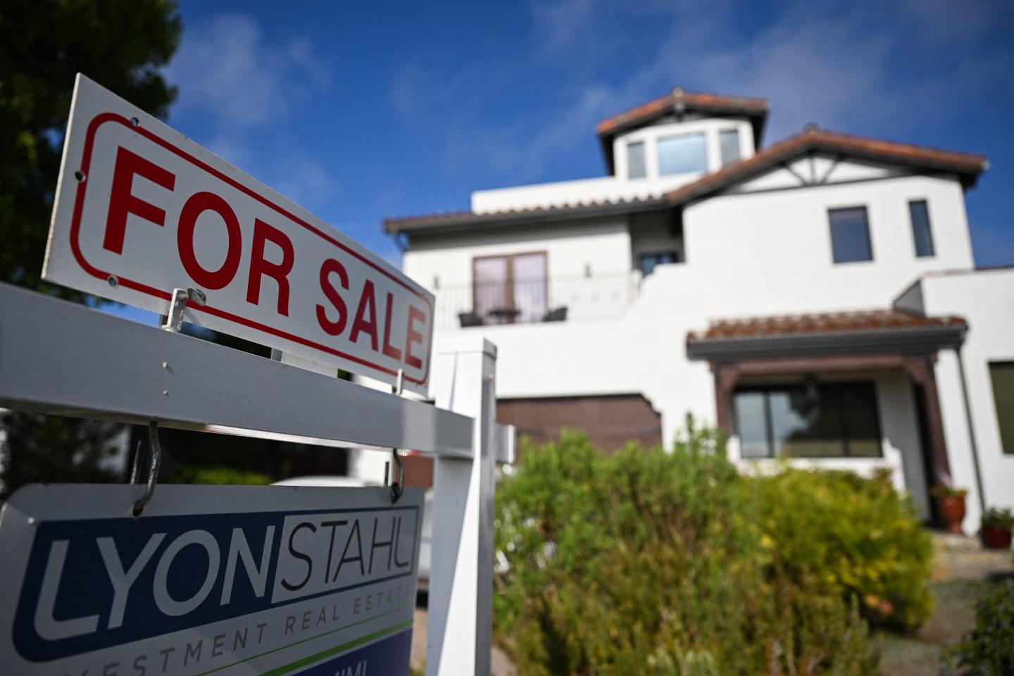 "For Sale" sign in front of house