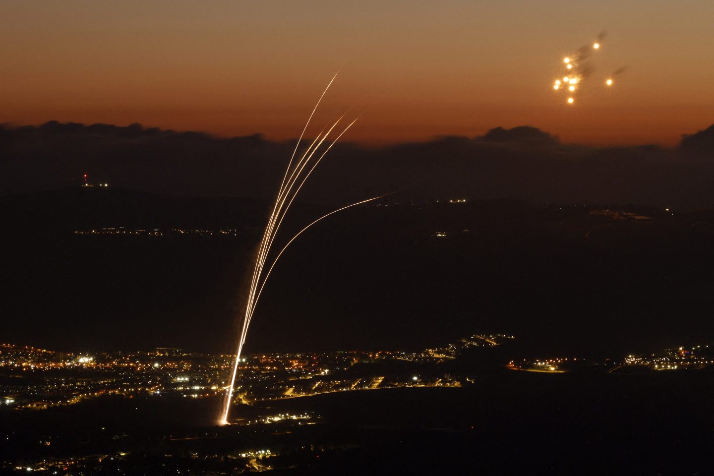Rockets fired from southern Lebanon are intercepted by Israel's Iron Dome air defence system over the Upper Galilee region in northern Israel.