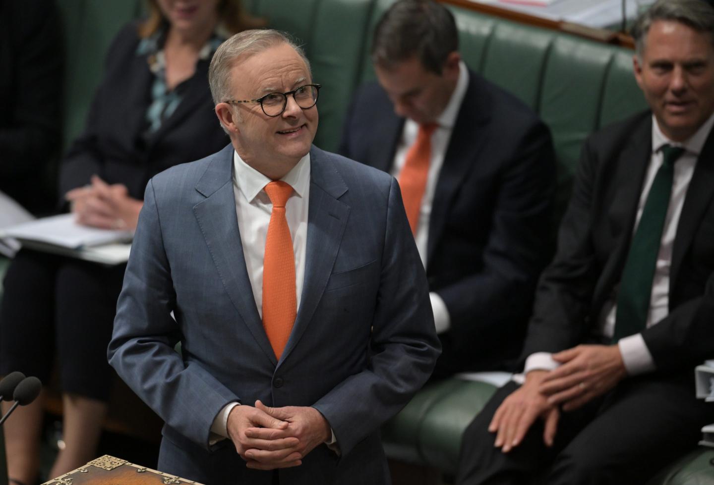 Prime Minister Anthony Albanese, dressed in a suit and orange tie, speaks at Question Time in the House of Representatives at Australian Parliament House in Canberra, Australia.