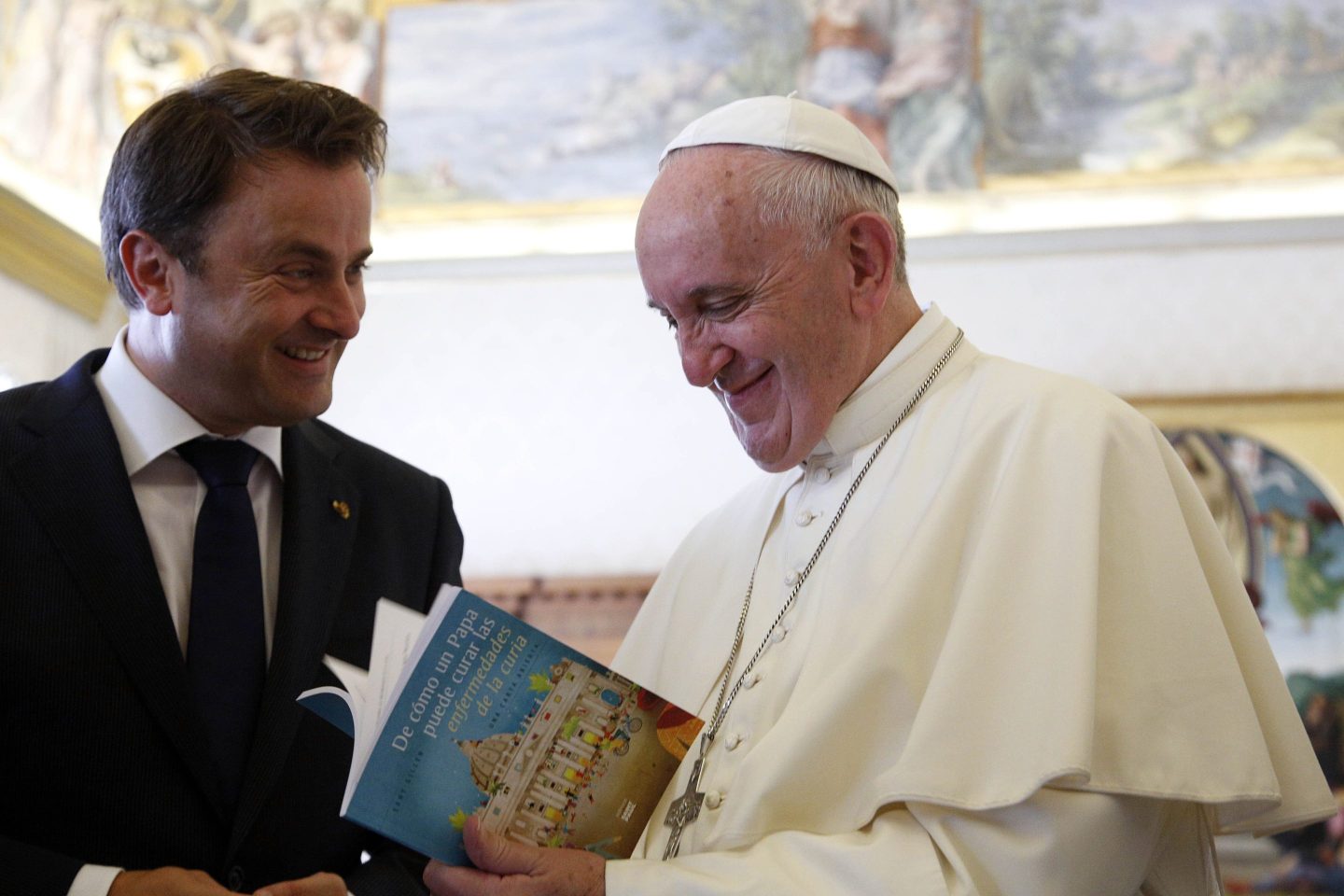 Pope Francis is presented by Luxembourg's Prime Minister Xavier Bettel (L) with a book titled: "Of how a Pope can cure diseases of the Curia" during a private audience at the Vatican, on September 17, 2015. AFP PHOTO POOLGREGORIO BORGIA (Photo credit should read GREGORIO BORGIA/AFP via Getty Images)