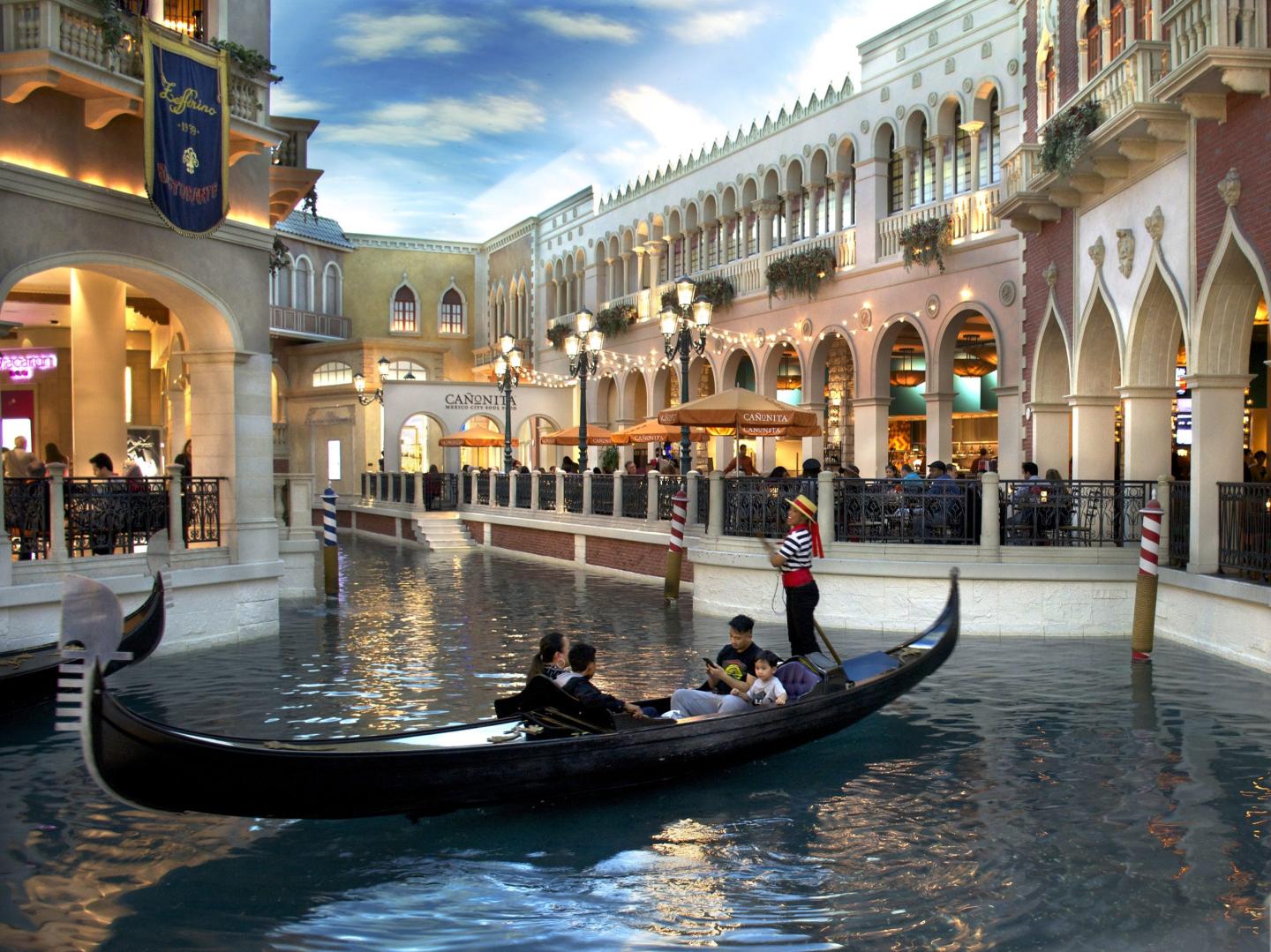 Tourists ride in a gondola inside the Venetian luxury hotel, casino and shopping complex