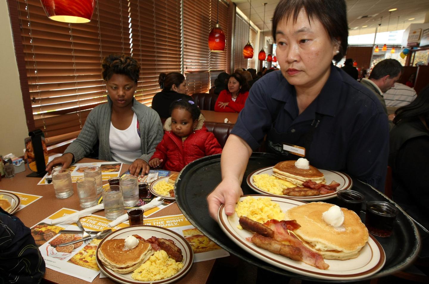 A waitress serving breakfast to diners