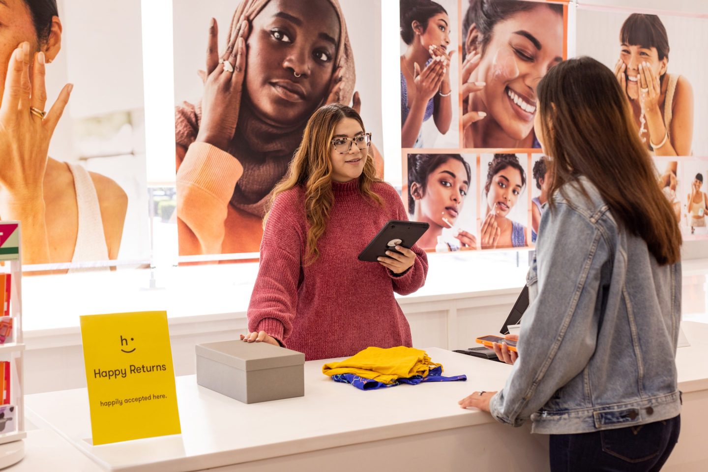 A store worker discusses a merchandise return with a customer at the counter