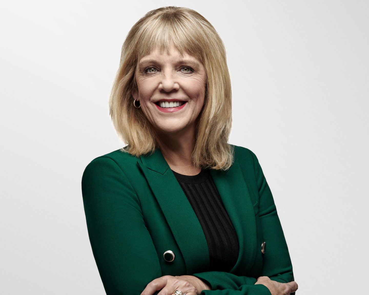 businesswoman wearing a green jacket poses for a portrait