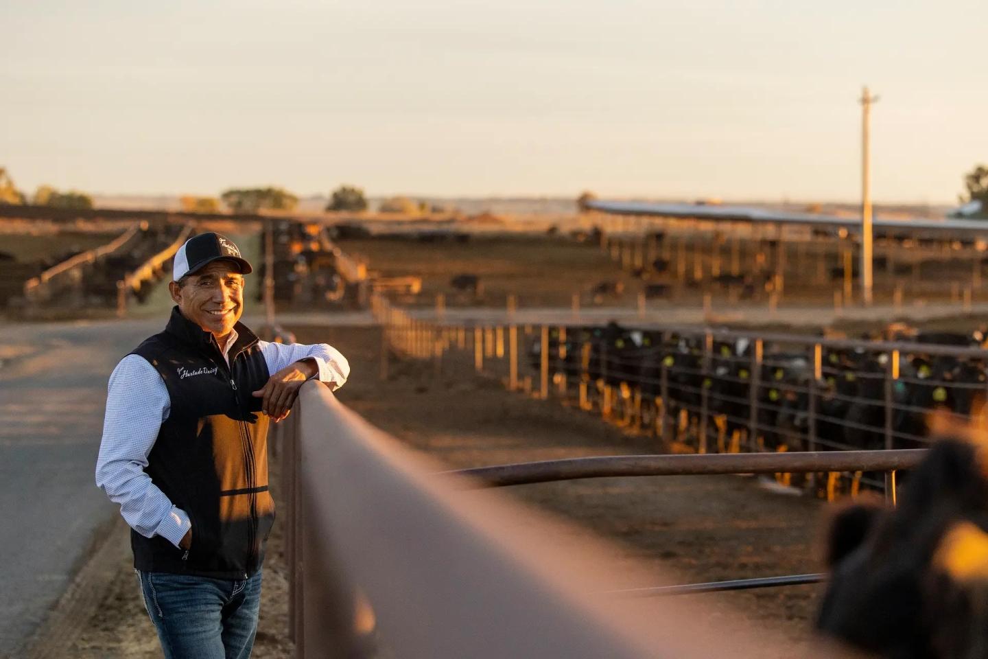 Dairy farmer Jesus Hurtado wheres a baseball hat in front of cows in a stable at Hurtado Dairy in Idaho, where he manages 30,000 cattle. Dairy processing facility Suntado co-founder