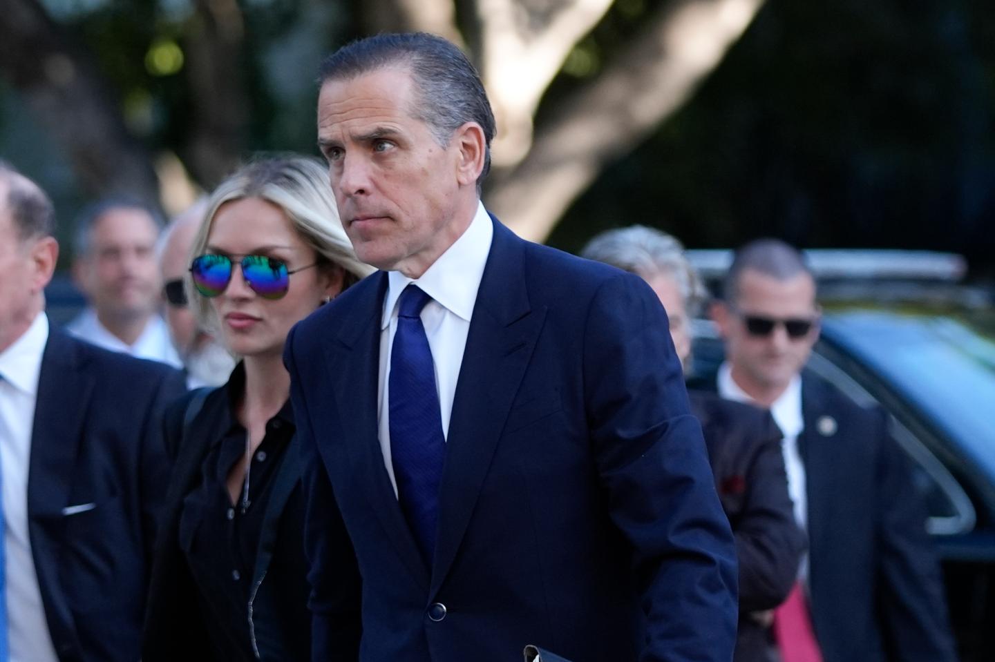 Hunter Biden is pictured outside the court room wearing a dark navy suit and tie.