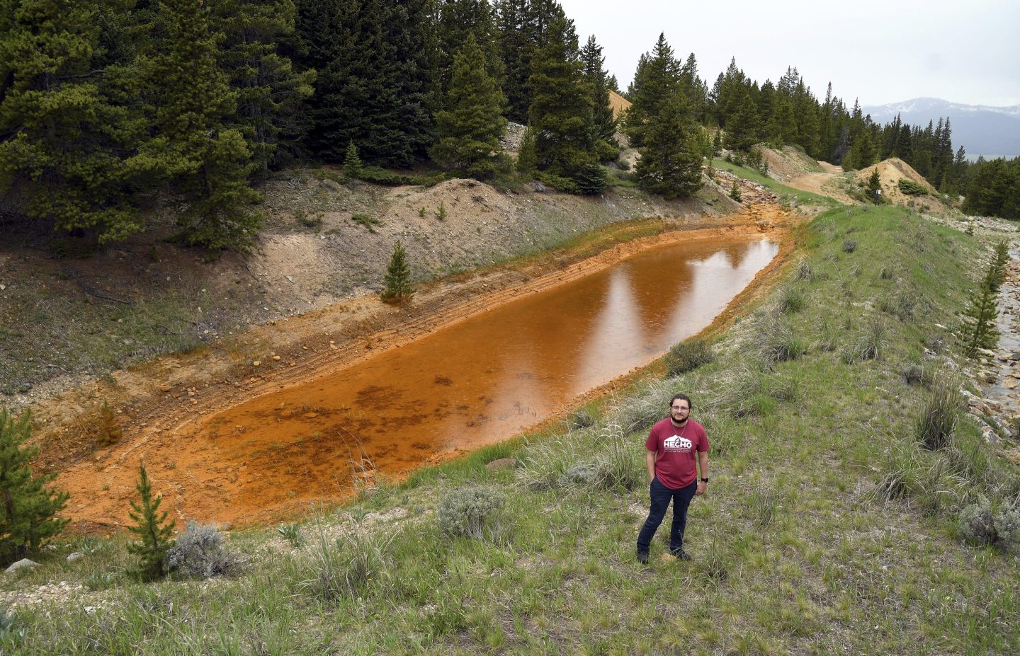 City councilmember Christian Luna-Leal in front of a detention pond containing mine waste in Leadville, Colo., on June 26, 2024.