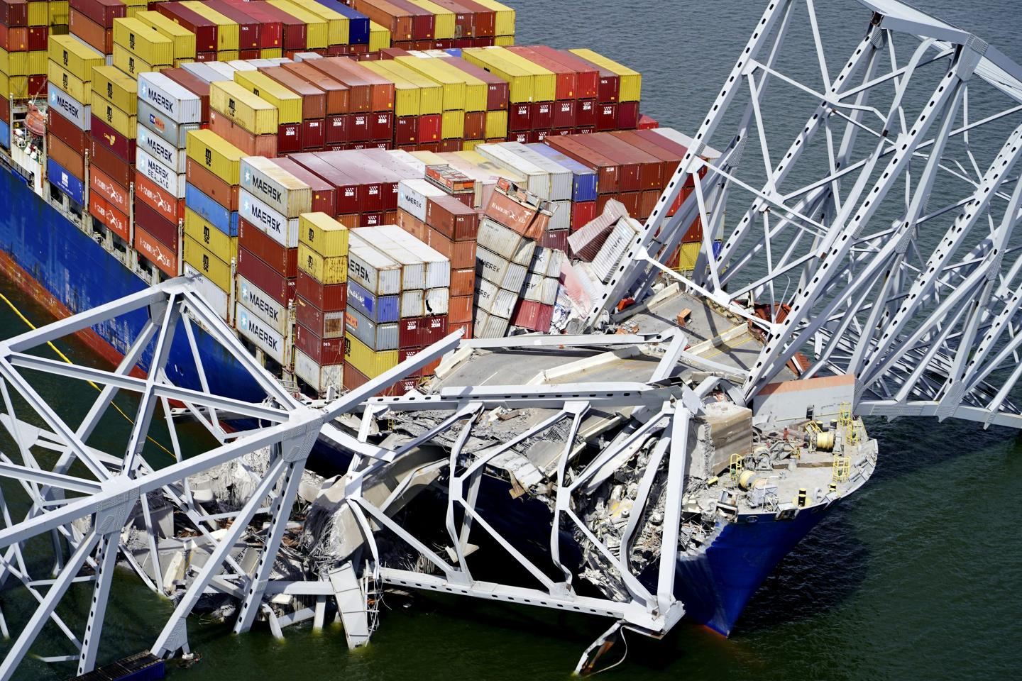 In this aerial image released by the Maryland National Guard, the cargo ship Dali is stuck under part of the structure of the Francis Scott Key Bridge after the ship hit the bridge.