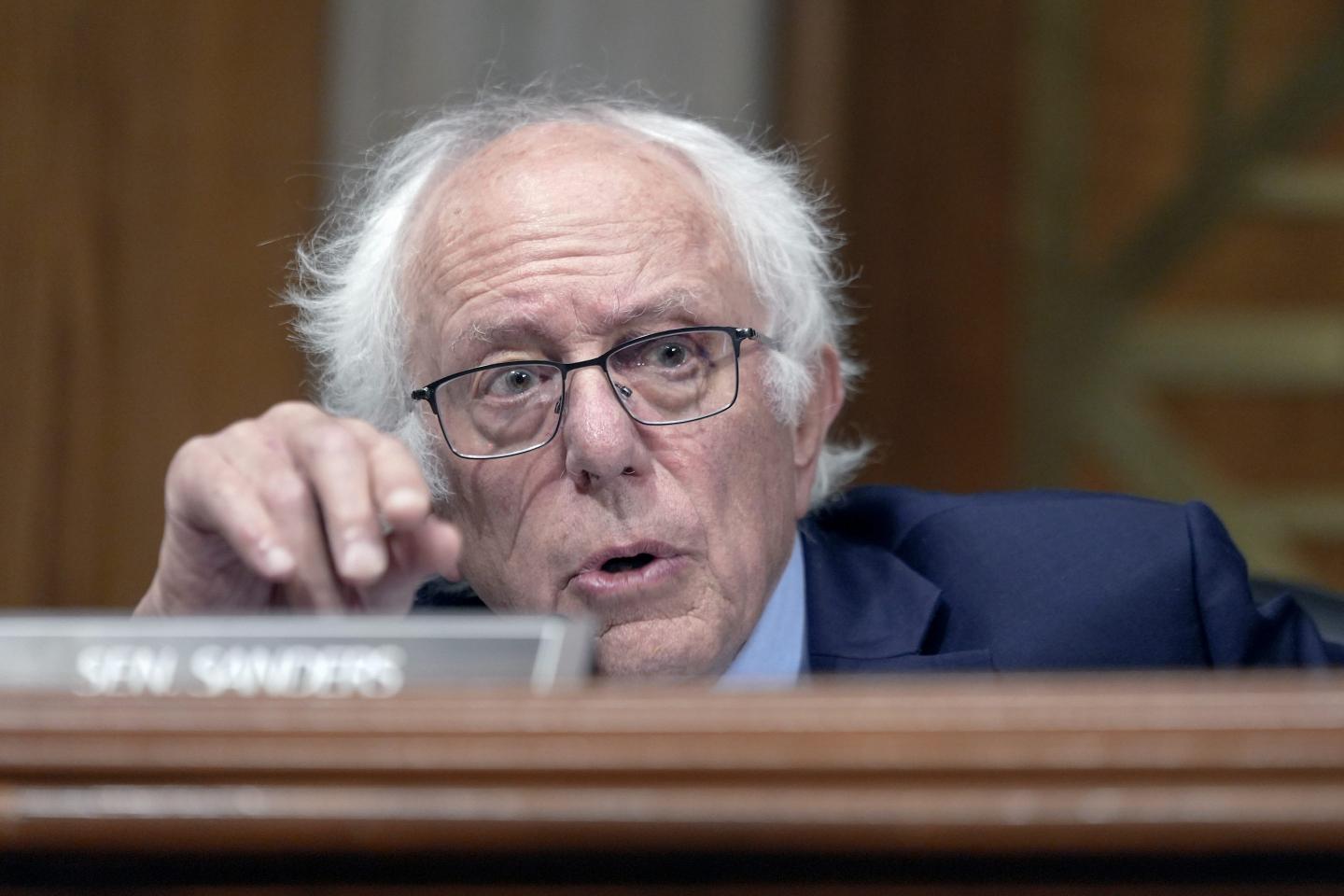 Sen. Bernie Sanders, I-Vt., speaks during a Senate Health, Education, Labor, and Pensions Committee business meeting. He is behind his name plate at a long desk and is gesturing with his right hand.