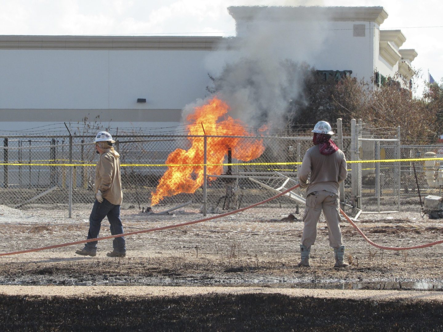 Workers stand near a pipeline fire in Deer Park, Texas, on Sept. 19, 2024.