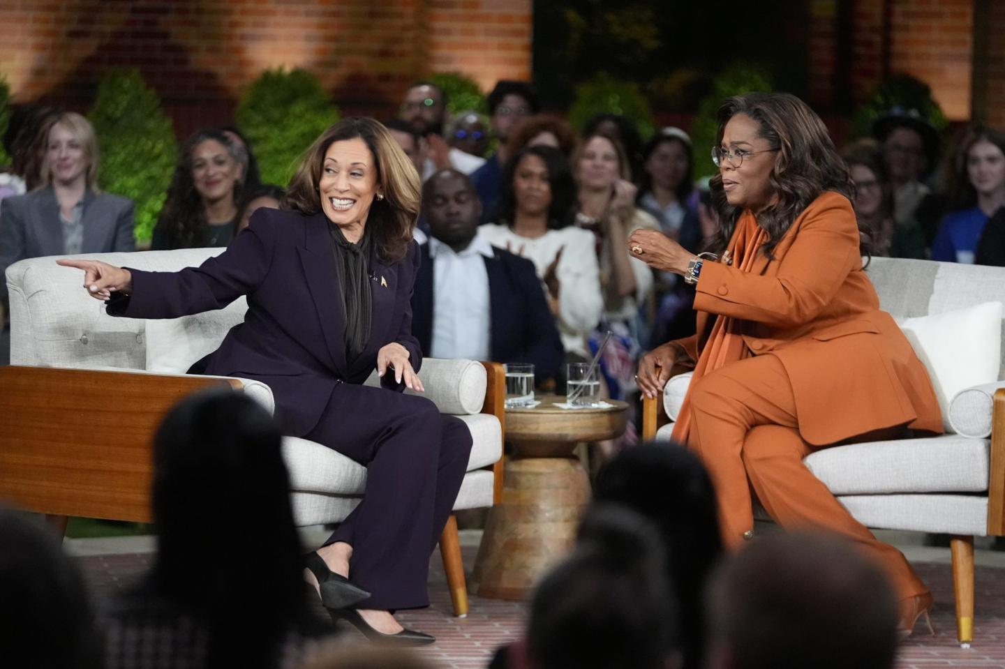 Kamala Harris sits on stage with Oprah Winfrey