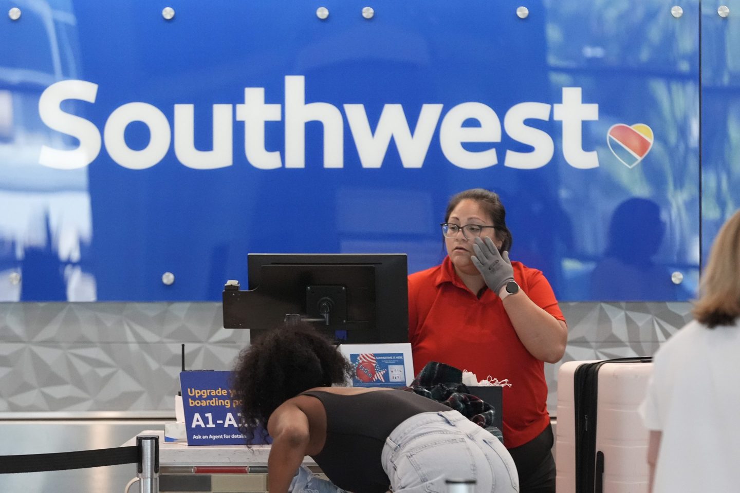 A Southwest Airlines ticket agent checks in passengers at Love Field in Dallas, July 25, 2024.