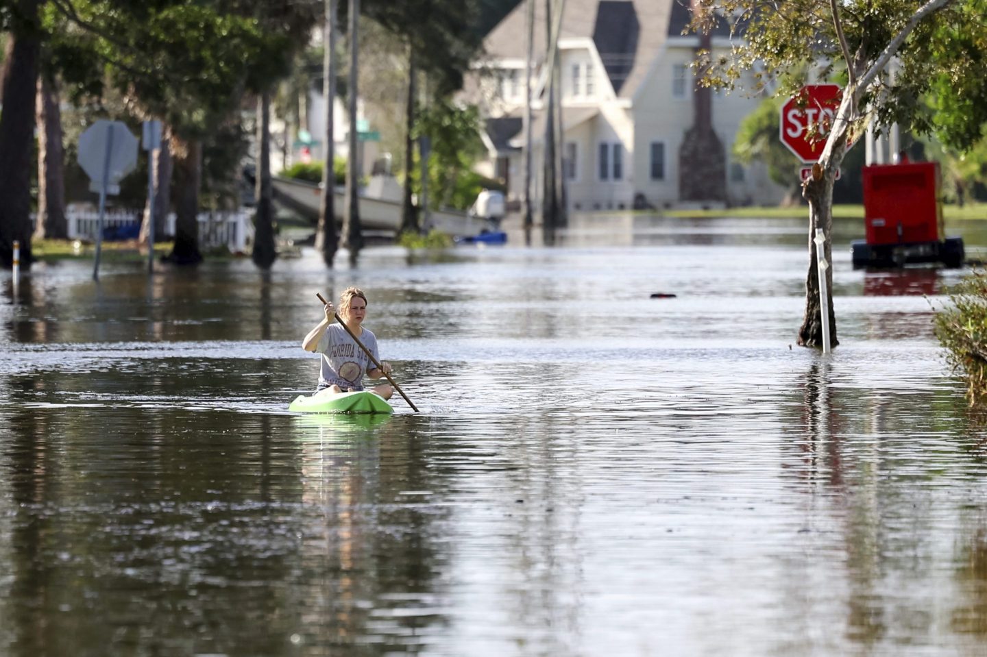 woman kayaks on flooded street