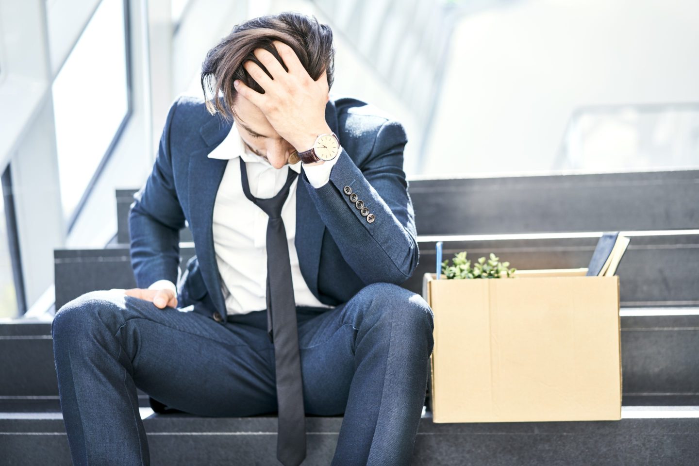 Depressed businessman sitting on stairs