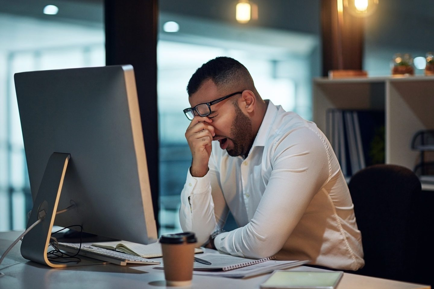 Man showing signs of fatigue while sitting in front of a computer.