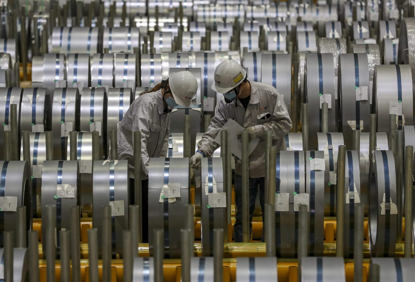 factory workers inspect metal