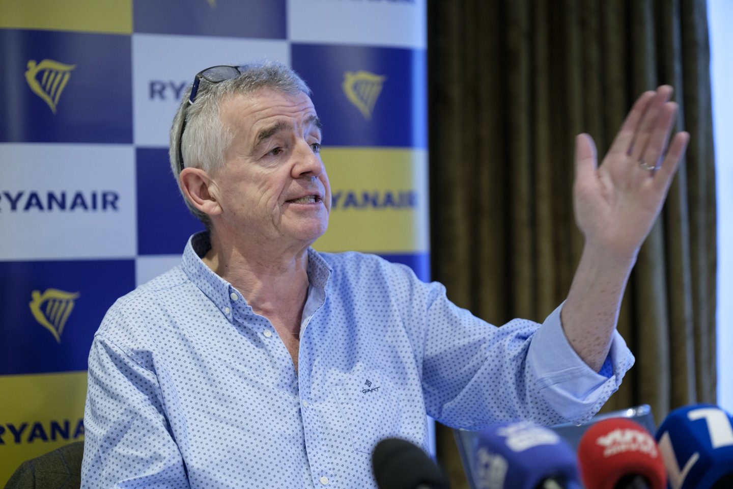 Ryanair CEO Michael O'Leary standing in front of Ryanair sign