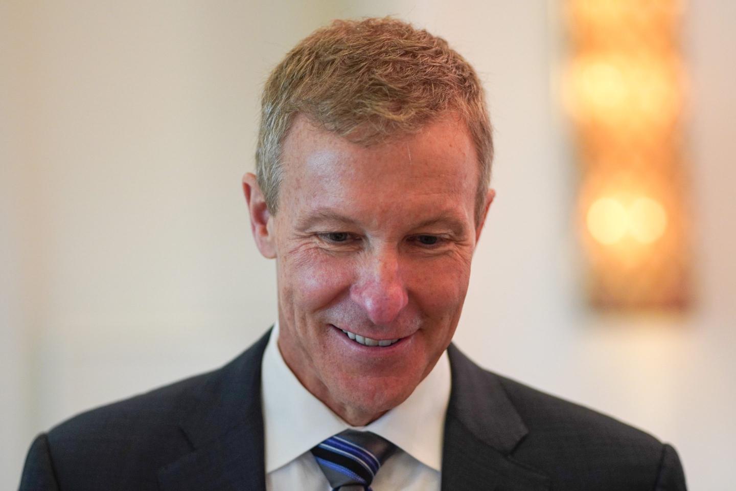 Scott Kirby smiles and looks down.