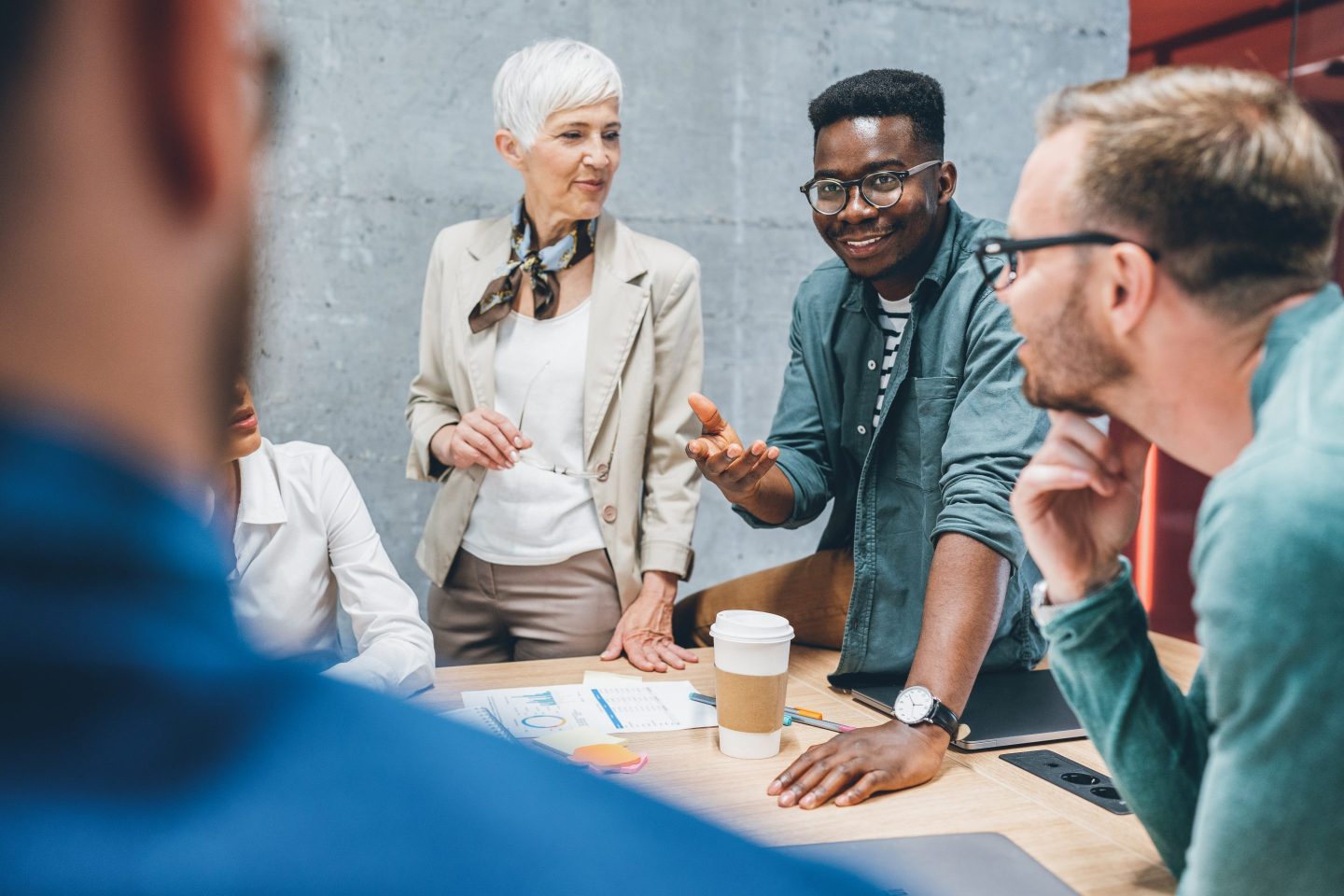 Workers of different ages gather together at office.
