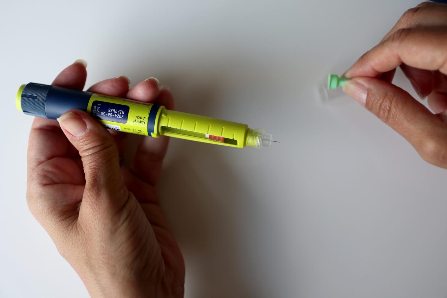In this photo illustration, an insulin pen manufactured by the Novo Nordisk company is being held and prepared for use.
