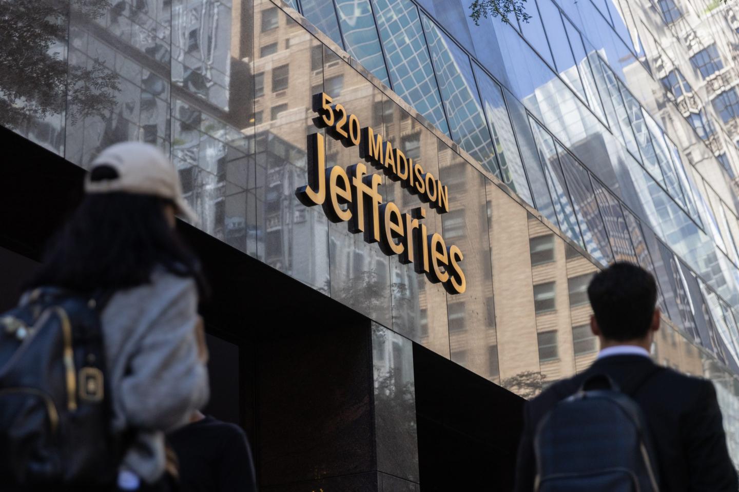 The exterior of a Jeffries Financial Group building in NYC as a person walks buy.