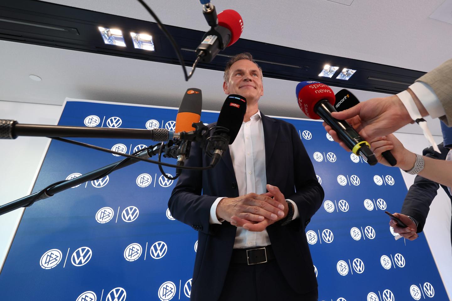 Oliver Blume, CEO of Volkswagen, standing with microphones surrounding him.
