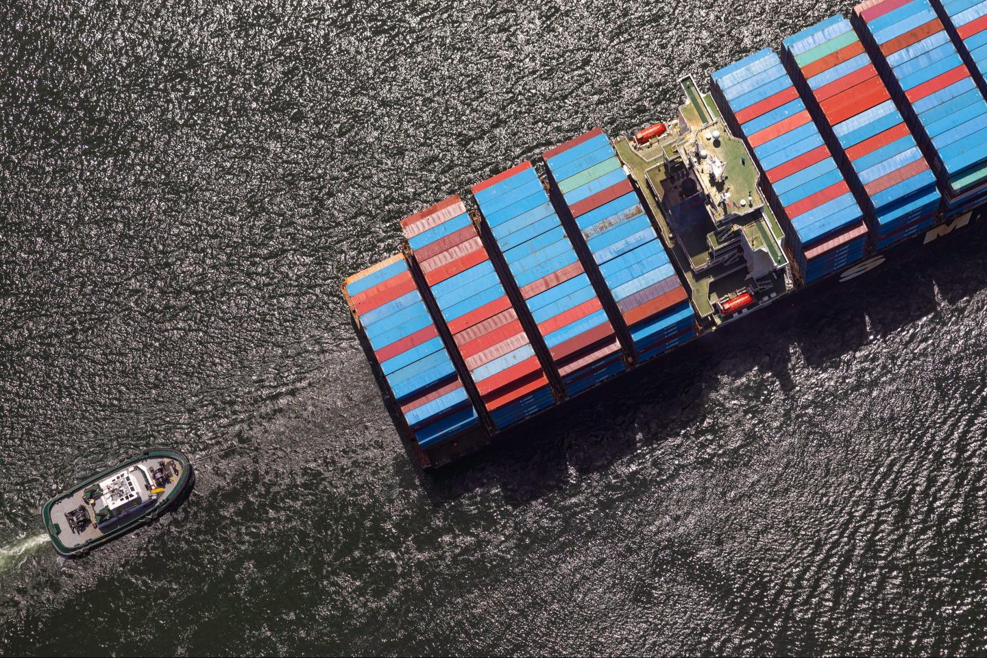 A photograph of a tug boat assisting a container ship to its berth at the Port of Long Beach in Long Beach, California, US, on Monday, June 17, 2024.