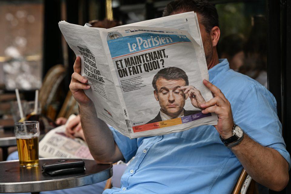 a person reading Le Parisien newspaper