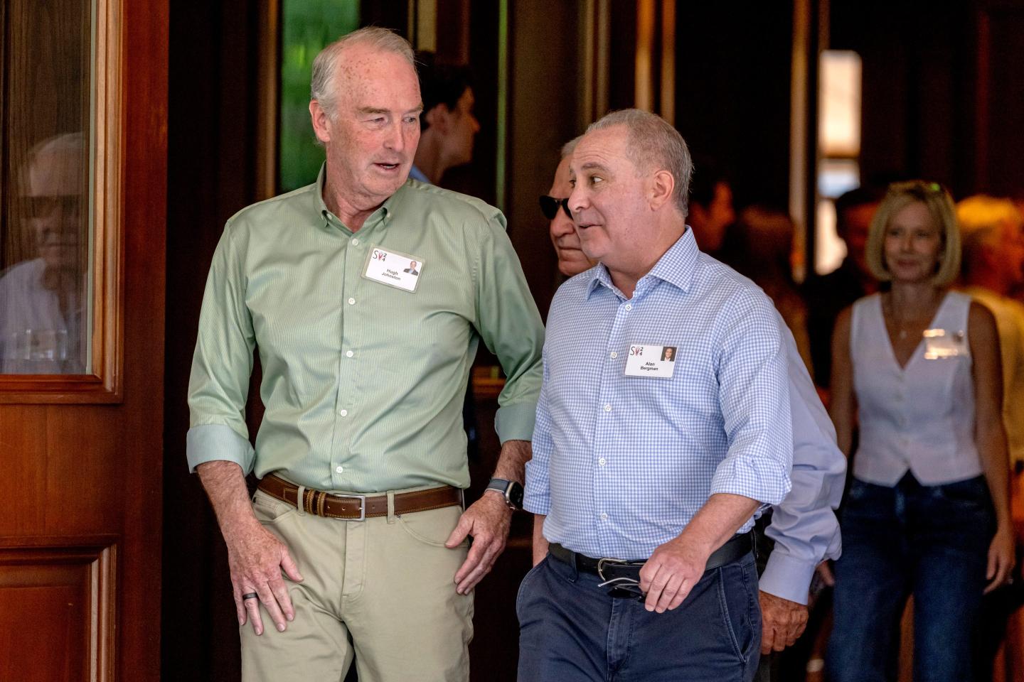 Disney CFO Hugh Johnston walking and talking with Alan Bergman, co-chairman of Disney Entertainment.