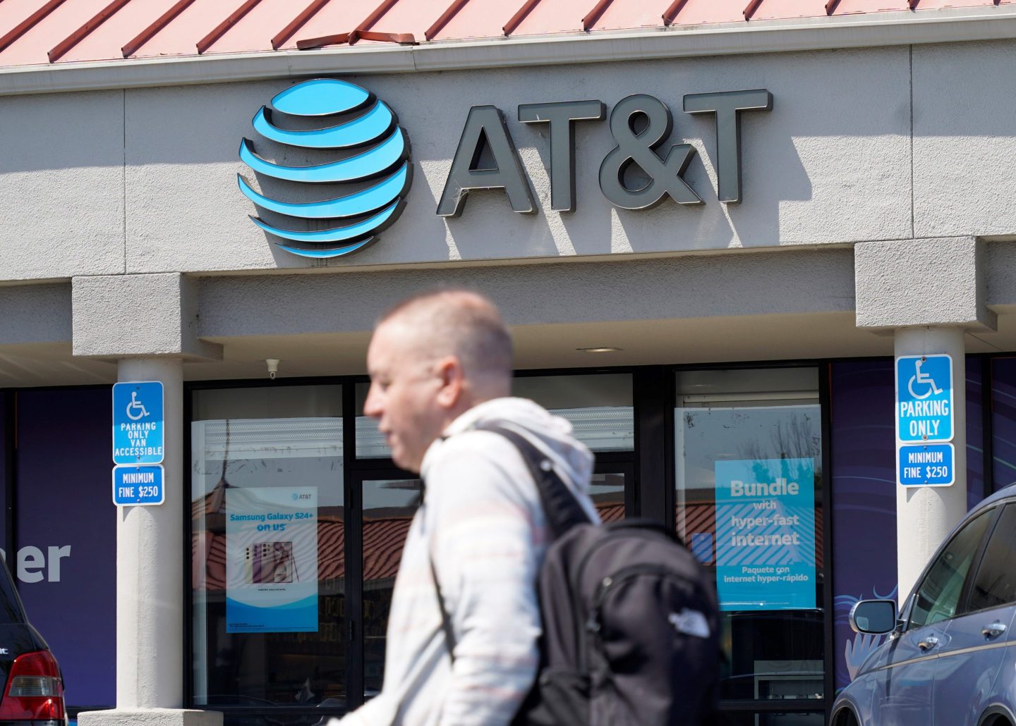 A man walks past an AT&T store in San Bruno, Calif., on July 12, 2024.
