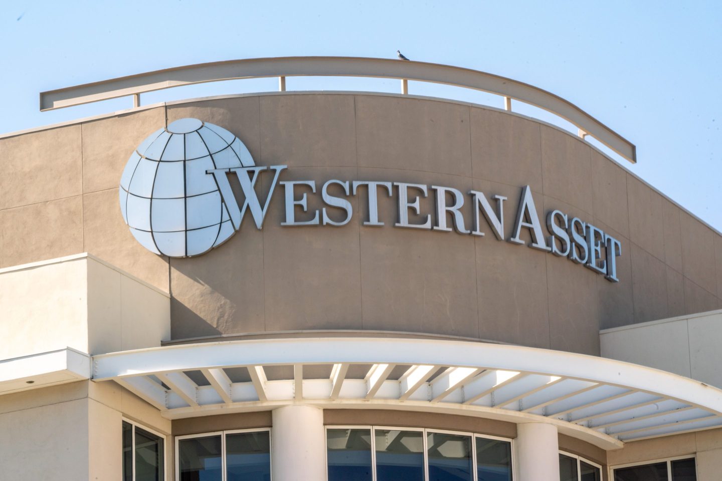 The exterior of a Western Asset Management building is seen partially in sun.