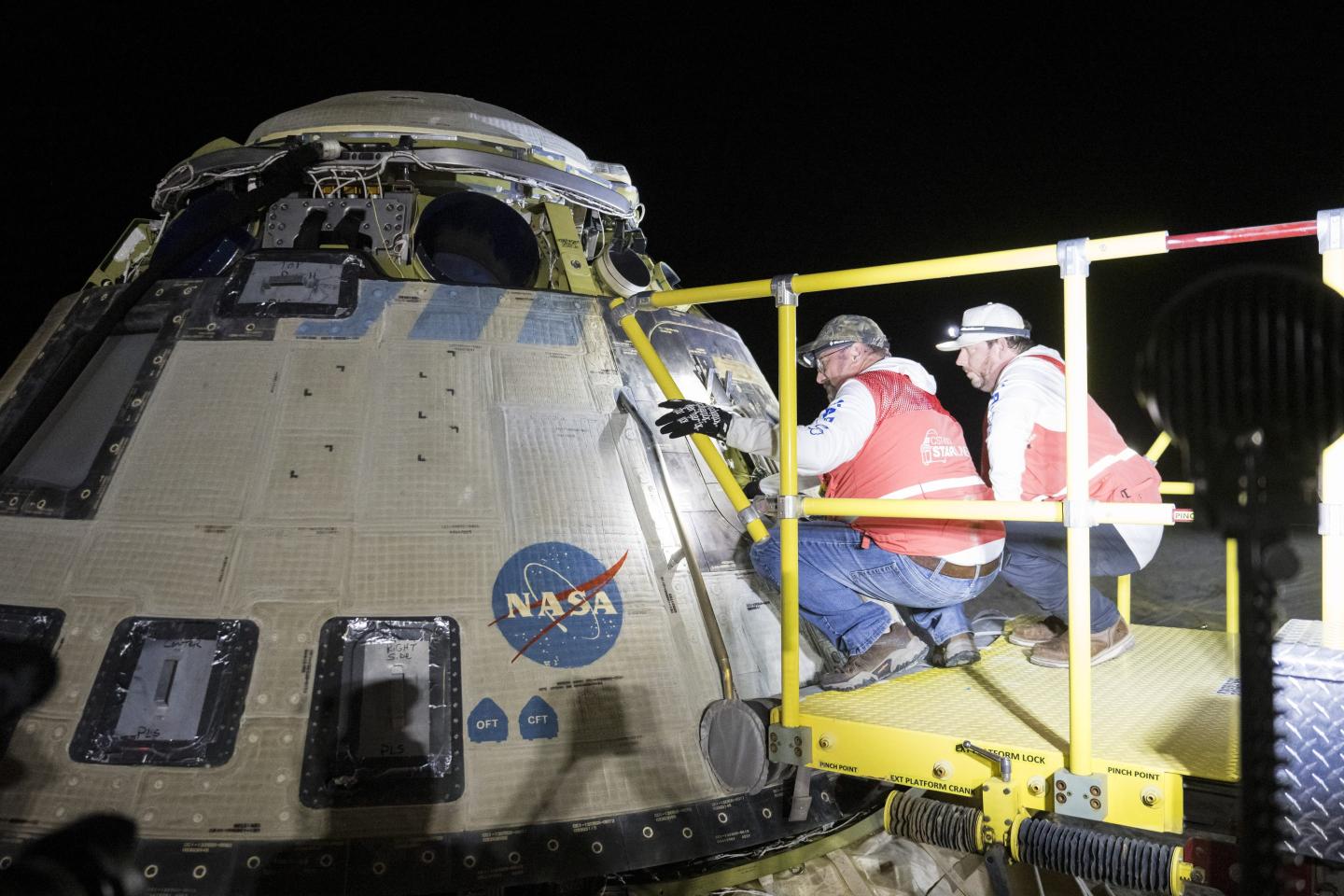 workers inspect space capsule