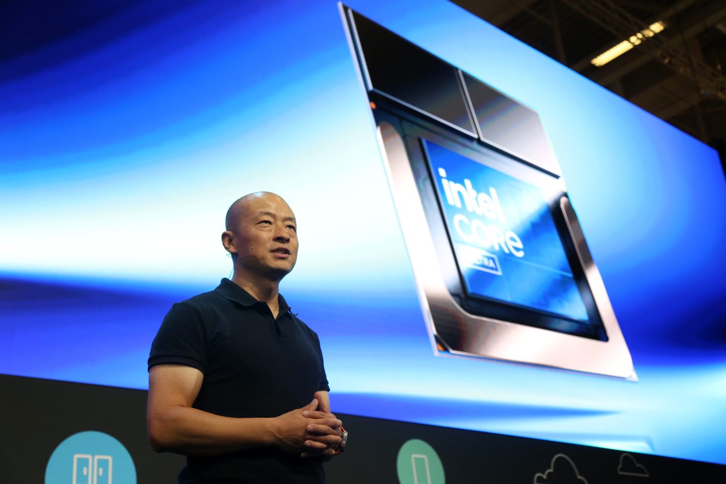 David Feng, Vice President and General Manager, Client Segments, Client Computing Group at Intel, speaks about Intel microchips in Samsung laptops. He is seen on a stage in front of a large image of an Intel chip with the company logo in it.
