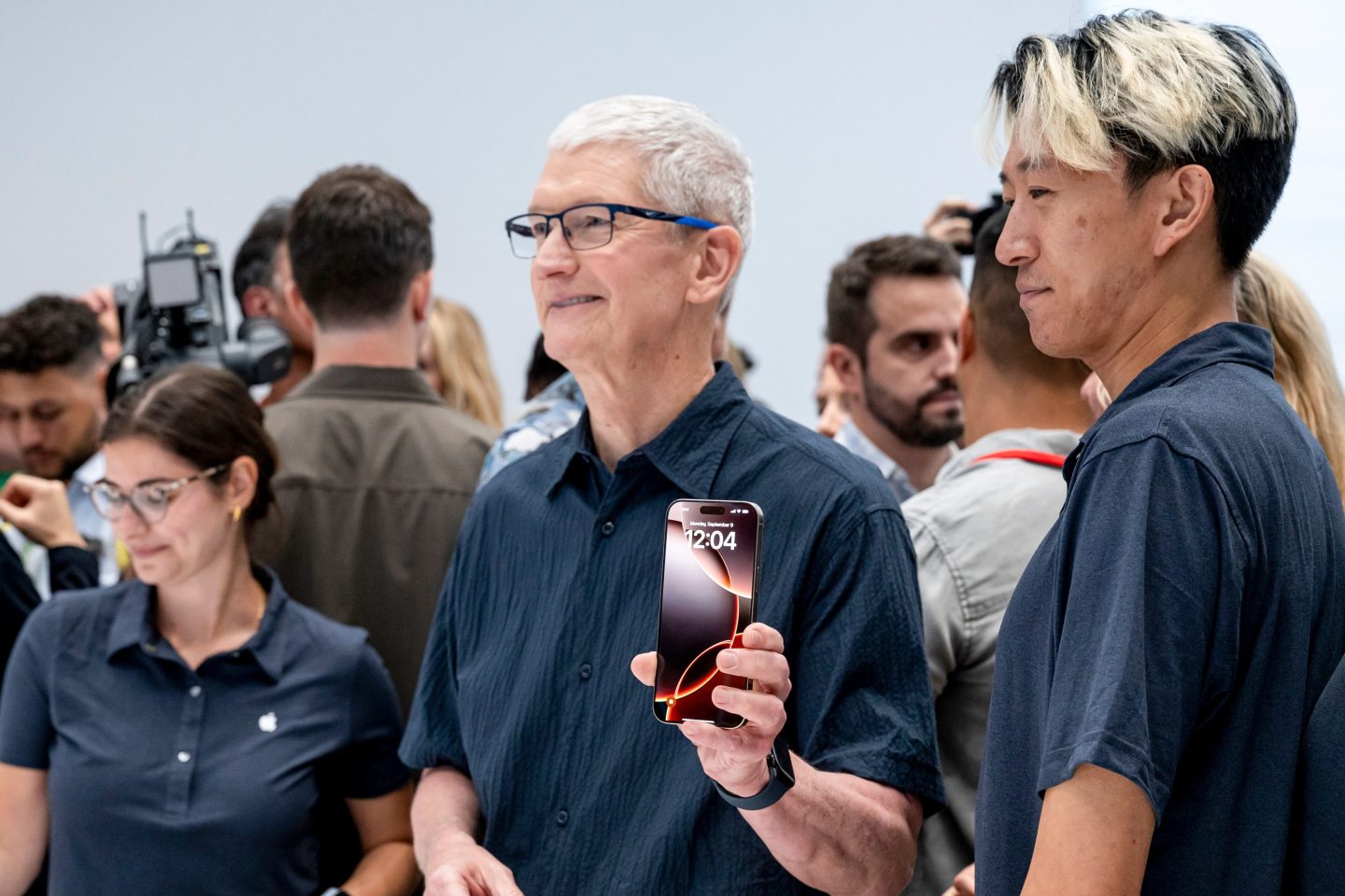 Tim Cook, chief executive officer of Apple Inc., center, with the new iPhone 16 Pro Max