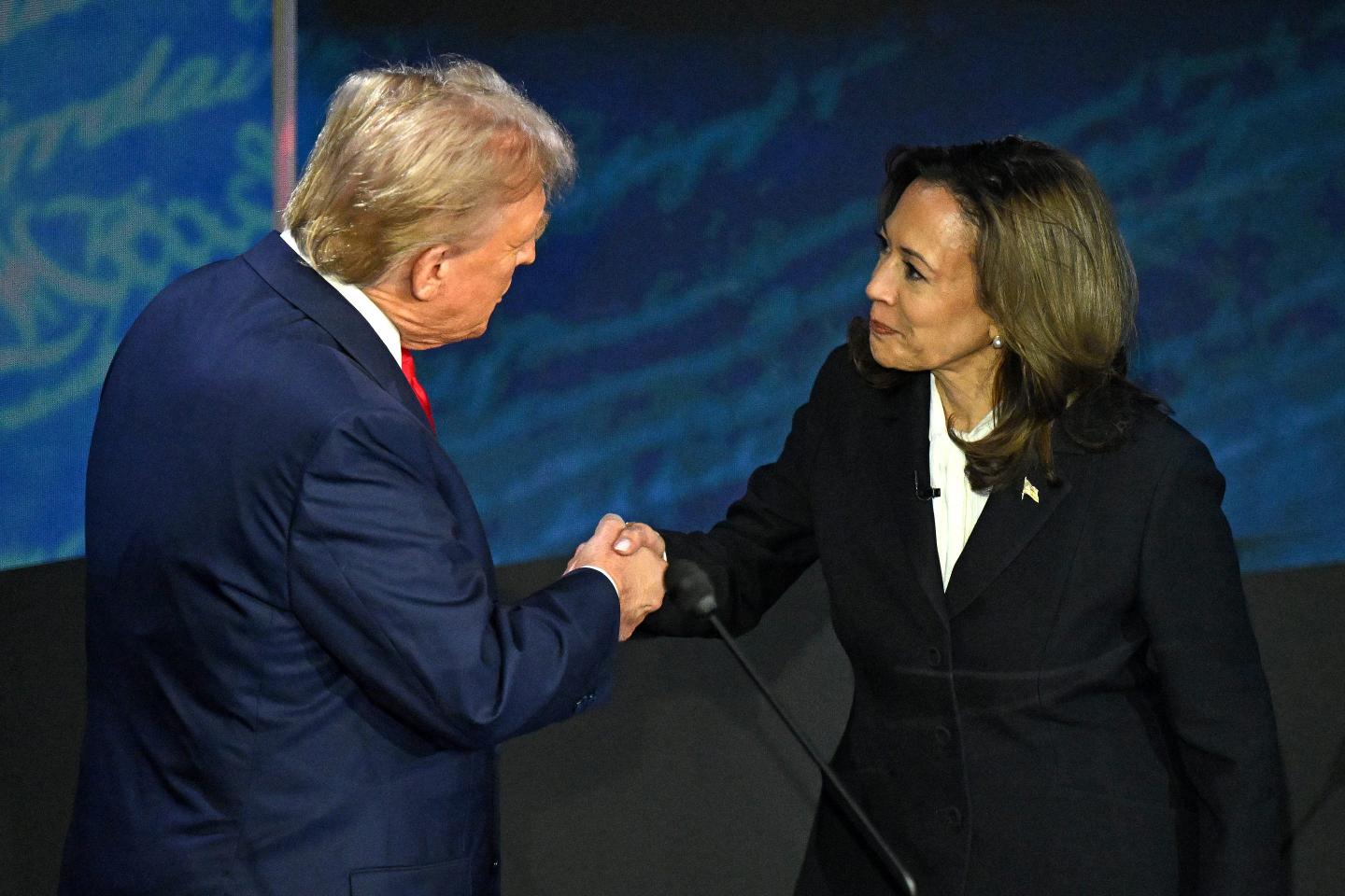 US Vice President and Democratic presidential candidate Kamala Harris (R) shakes hands with former US President and Republican presidential candidate Donald Trump during a presidential debate.