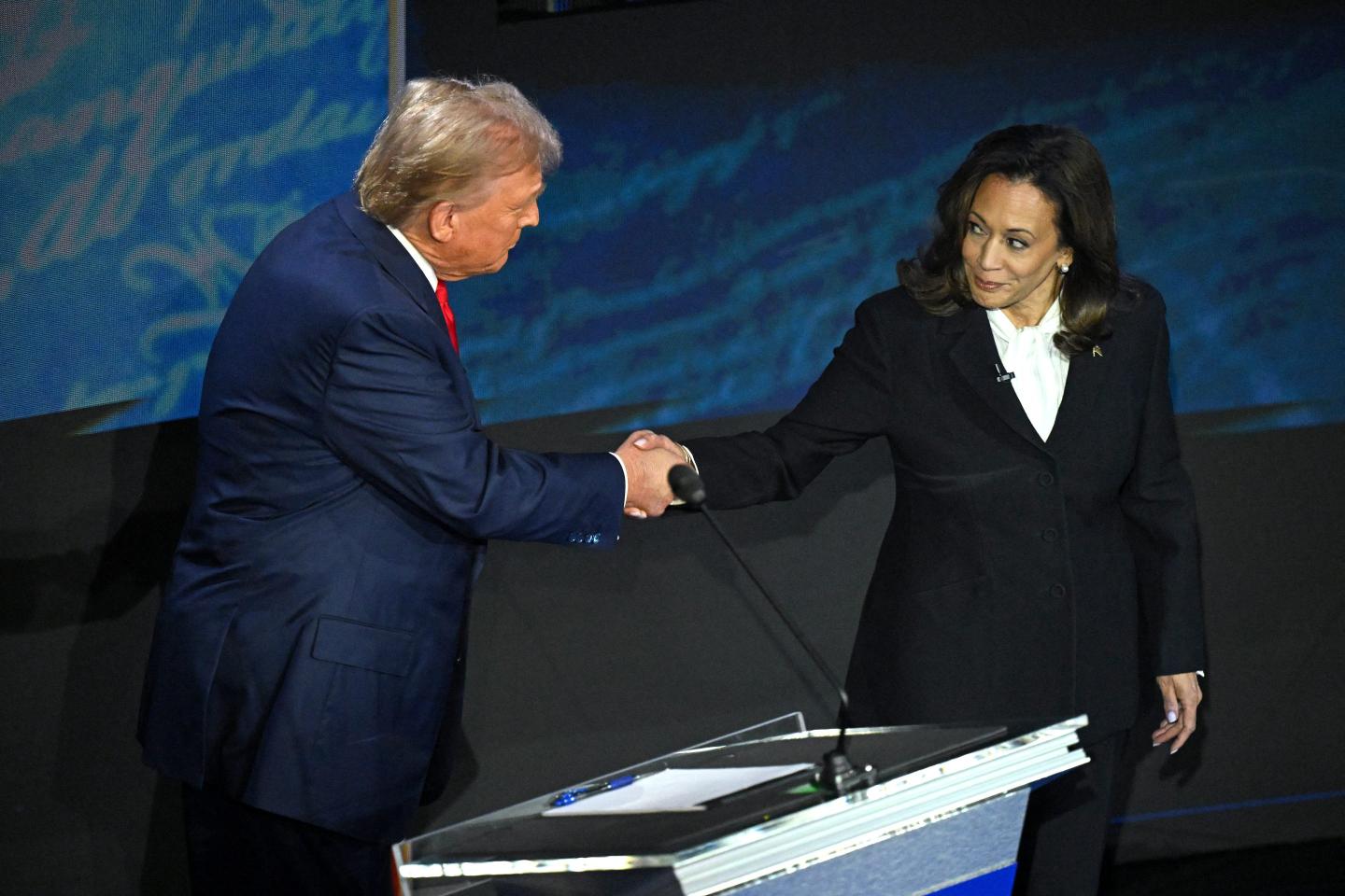 Donald Trump and Kamala Harris shake hands