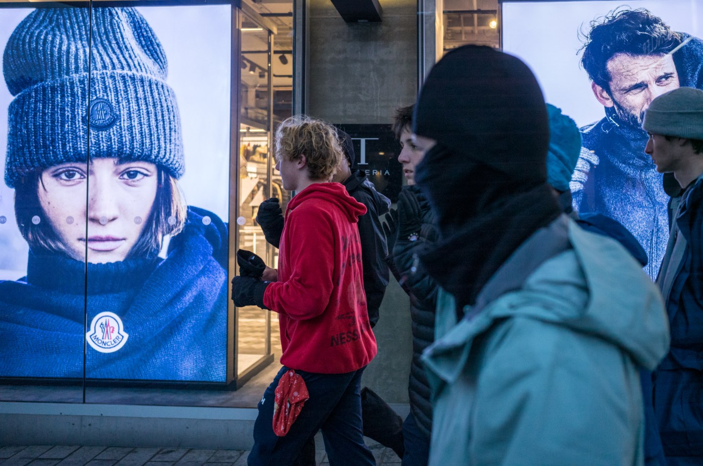 Pedestrians walk past a Moncler SpA store