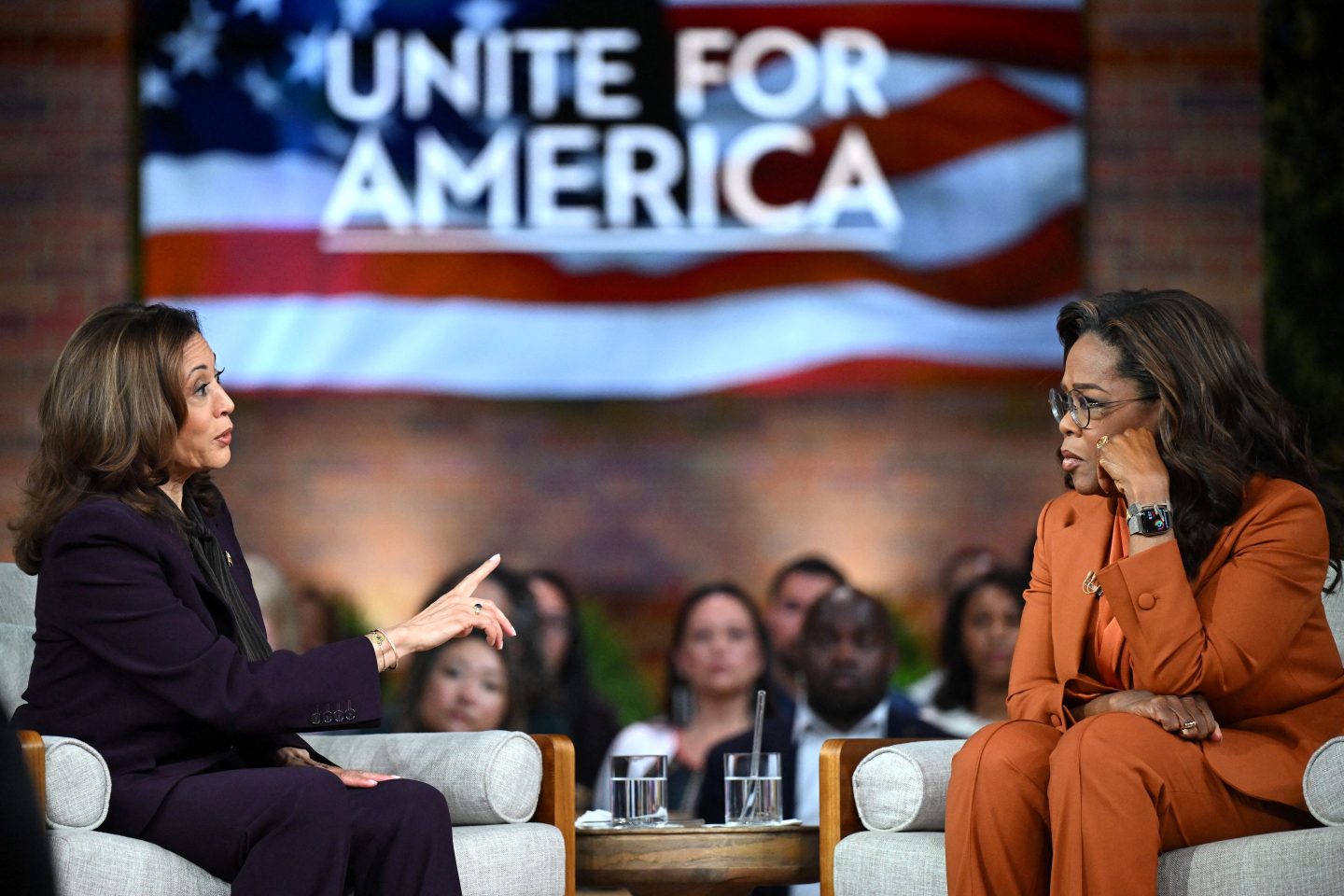 Kamala Harris sits across from Oprah Winfrey at a "Unite for America" election rally.