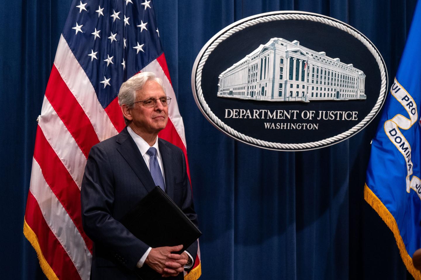 Attorney General Merrick Garland in front of the Justice Department sign.