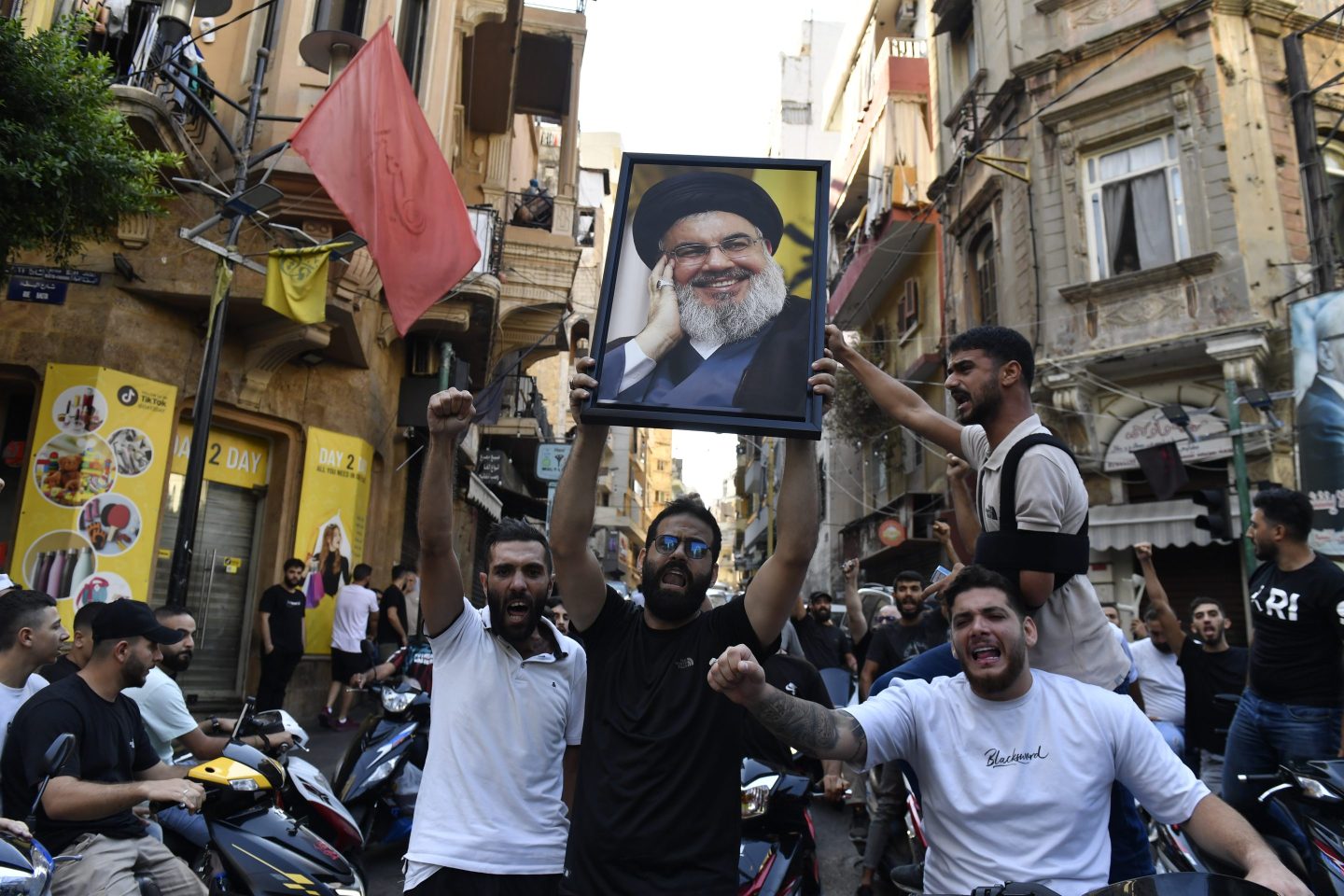 men holding picture of Hassan Nasrallah