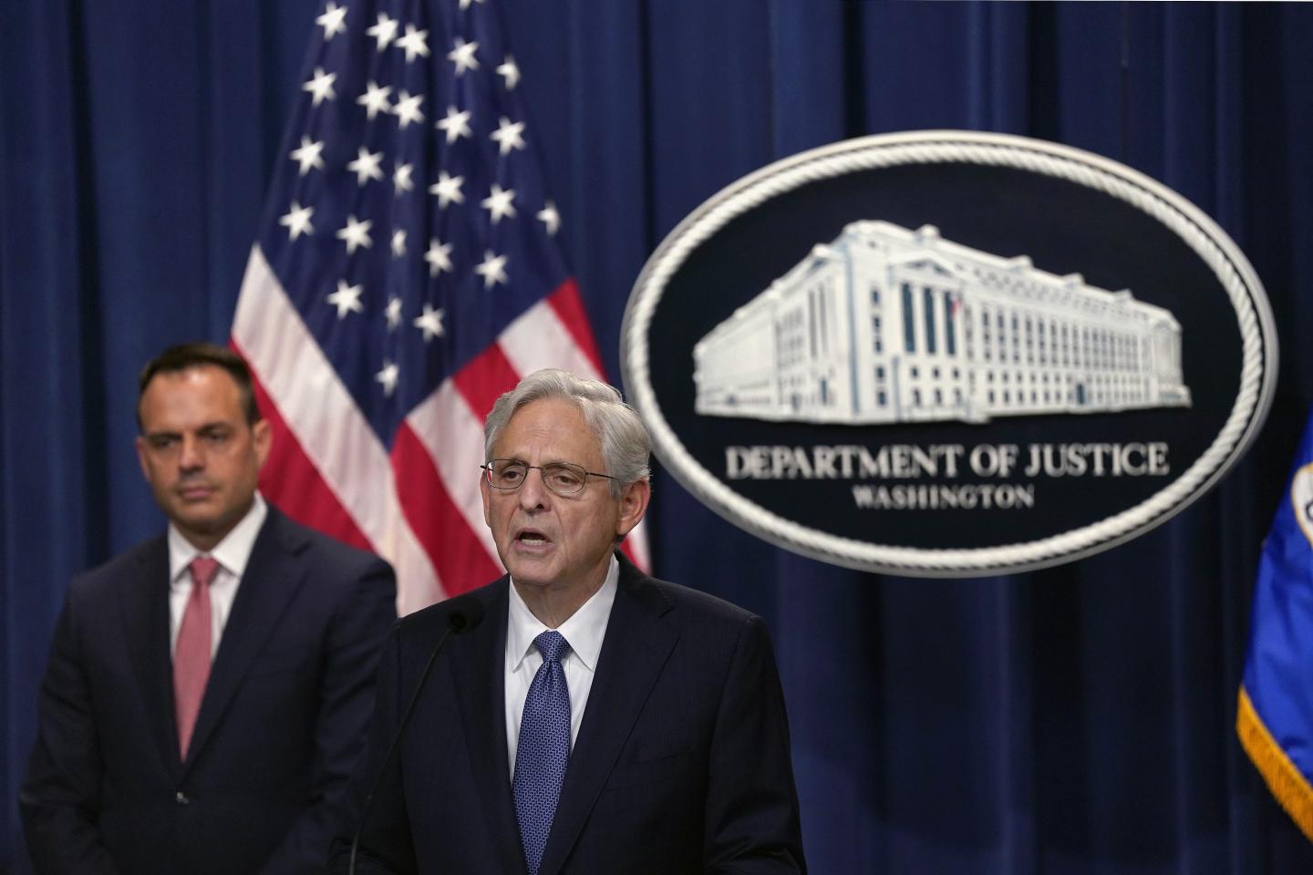 Merrick Garland speaks on stage at a press conference.