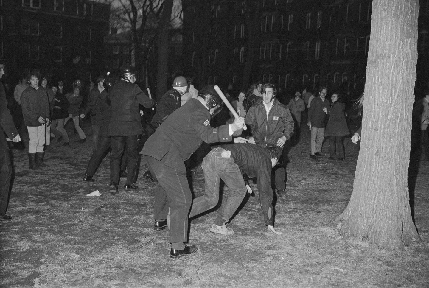 Police officers hit a student during a protest at Harvard University protest.