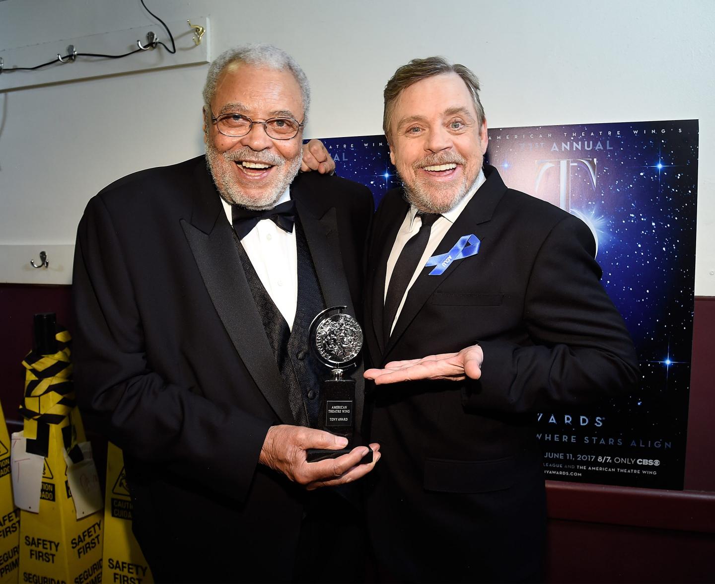 James Earl Jones in a tuxedo holds an award while standing next to Mark Hamill.