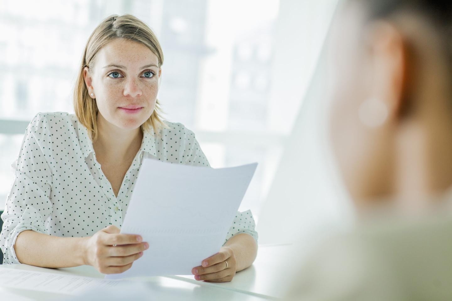 Hiring manager sits with job candidate.