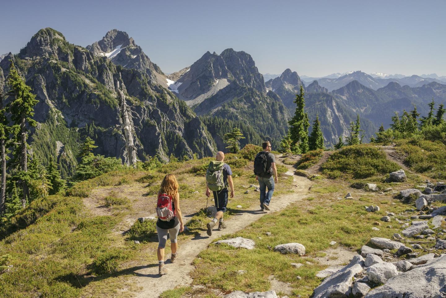 People hike with a mountain in the background