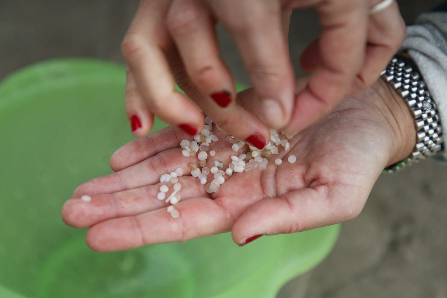 A volunteer holds plastic pellets spilled from a transport ship collected from a beach in Nigran, Pontevedra, Spain.