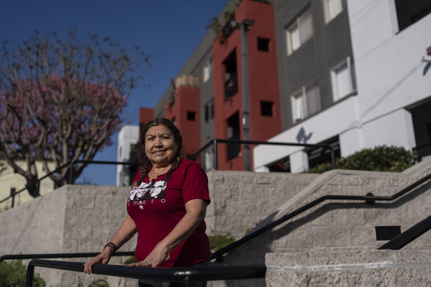 woman stands outside apartment building