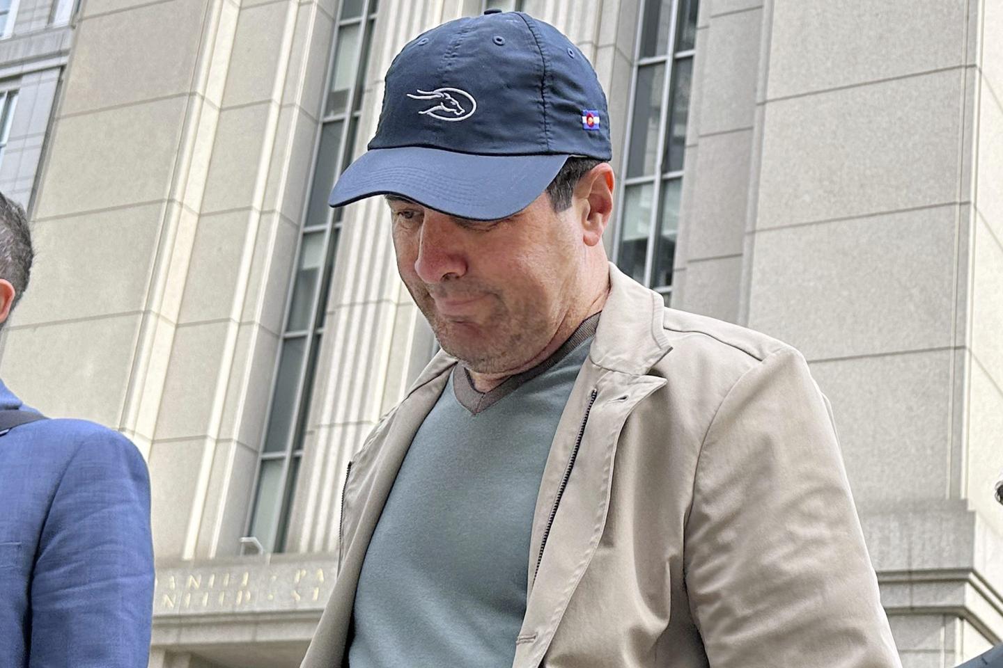 Gregory Gumucio, 63, leaves court in a baseball cap.