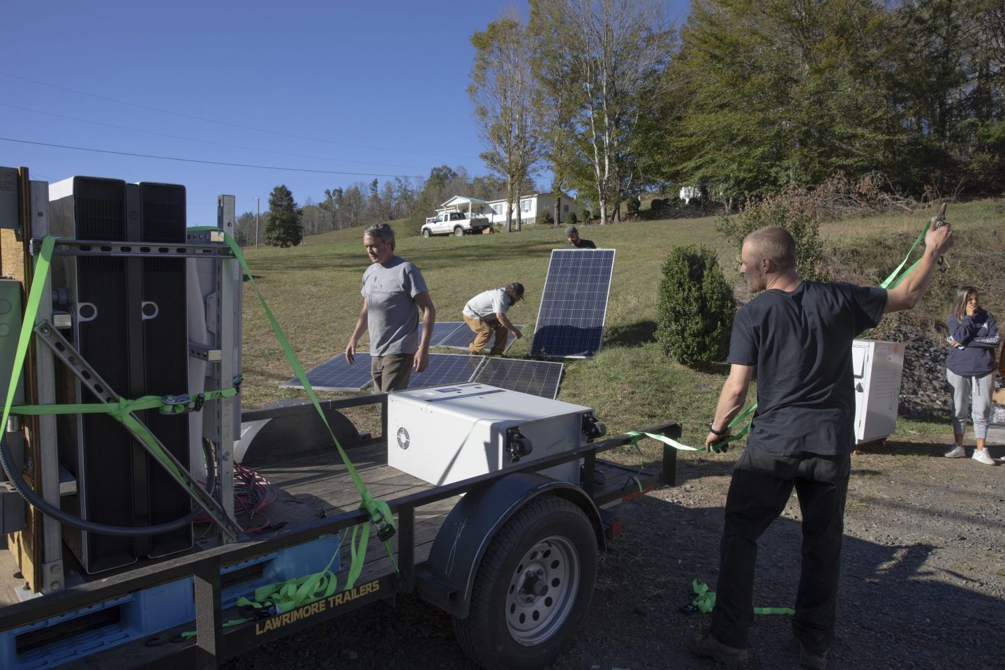 Hayden Wilson, left, Jonathan Bowen, second from left, Alexander Pellersels second from right, and Henry Kovacs, right, install a mobile power system for a resource hub in Tipton Hill, N.C. on Oct. 9, 2024.
